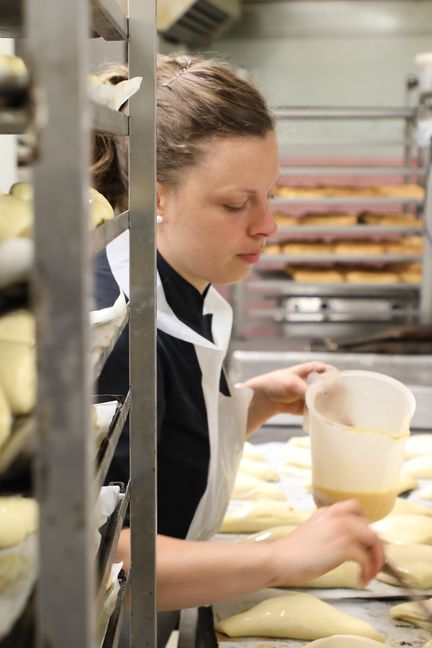 Anaëlle Morice dore des viennoiseries dans les cuisines de la pâtisserie Gaël, à Muzillac (Morbihan), le 2 mai 2019.&nbsp; (VALENTINE PASQUESOONE / FRANCEINFO)