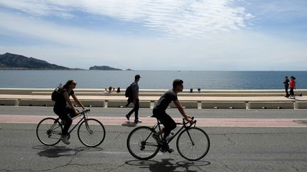 Des cyclistes se baladent à vélo, le 23 mai 2021 à Marseille. (NICOLAS TUCAT / AFP)