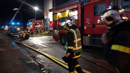 Des pompiers s'efforcent d'éteindre l'incendie dans deux immeubles du quartier Saint-Julien de Rouen (Seine-Maritime), le 1ᵉʳ octobre 2023. (LOU BENOIST / AFP)