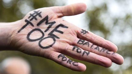 Le hashtag&nbsp;#MeToo inscrit sur la main d'une personne manifestant à Paris, le 29 octobre 2017. (BERTRAND GUAY / AFP)