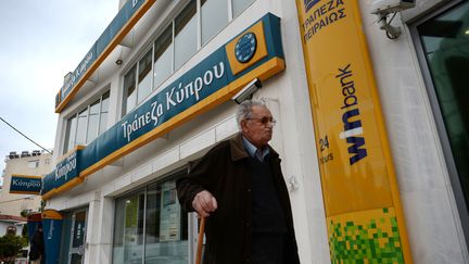 Un homme passe devant une agence de Bank of Cyprus, le 27 mars 2013, &agrave; Ath&egrave;nes (Gr&egrave;ce). (ARIS MESSINIS / AFP)