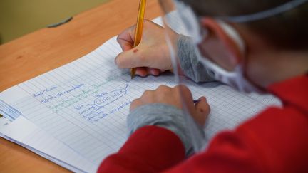 Un collégien portant un masque et une visière en classe à Angers, le 18 mai 2020. (DAMIEN MEYER / AFP)