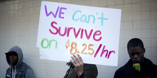 Des manifestants demandent des hausses de salaires à l'extérieur d'un fast-food McDonald à Oakland (Californie). Sur leur pancarte, on peut lire: «Nous ne pouvons pas survivre avec 8,25 dollars (6,17 dollars, NDLR) de l'heure».  (Reuters - Noah Berger)