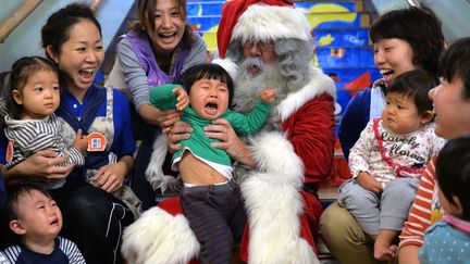 Lors d'une s&eacute;ance photo organis&eacute;e par la compagnie Finnair entre le p&egrave;re No&euml;l et de jeunes enfants &agrave; Tokyo (Japon), le 9 d&eacute;cembre 2013. (YOSHIKAZU TSUNO / AFP)