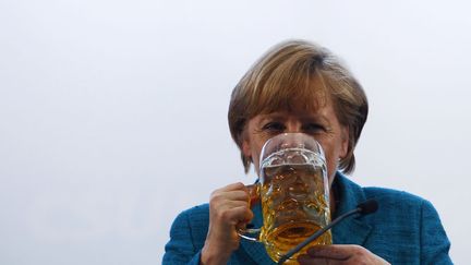 La chanceli&egrave;re allemande, Angela Merkel, boit une bi&egrave;re apr&egrave;s un discours &agrave; Munich (Allemagne), le 15 mai 2013. (MICHAELA REHLE / REUTERS)