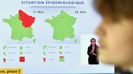 Une personne regarde la télévision avec la carte de la situation épidémiologiste en France le 11 mai et le 28 mai, le Val-d'Oise y est toujours classé en rouge (photo d'illustration). (ALEXANDRE MARCHI / MAXPPP)