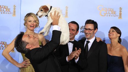 Le producteur de "The Artist", Thomas Langmann, fait joujou avec le chien du film, Uggie, devant une partie de l'&eacute;quipe : Missi Pyle, Jean Dujardin, le r&eacute;alisateur Michel Hazanavicius et B&eacute;r&eacute;nice Bejo (de g. &agrave; dr.). (LUCY NICHOLSON / REUTERS)