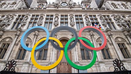 Les anneaux olympiques sont visibles sur le fronton de l'hôtel de ville de Paris, le 13 mars 2023. (ALAIN JOCARD / AFP)