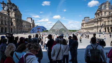 Selon l'Insee, un des principaux moteurs de la croissance au deuxième trimestre est le tourisme étranger en France, comme ici le 25 mai 2022 devant la pyramide du Louvre à Paris. (RICCARDO MILANI / HANS LUCAS / AFP)