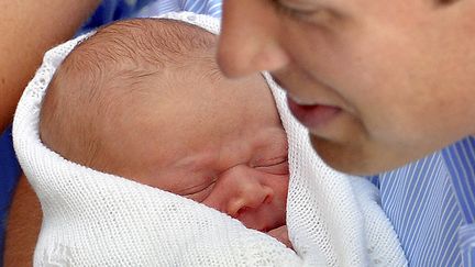 Le prince William tient son b&eacute;b&eacute; dans les bras &agrave; la sortie de l'h&ocirc;pital St Mary &agrave; Londres (Royaume-Uni), le 23 juillet 2013. (REUTERS)