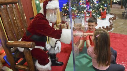 Un Père Noël avec deux enfants dans un magasin Cabela's aux États-Unis, en novembre 2020. (MEDIANEWS GROUP/READING EAGLE VI / MEDIANEWS GROUP RM via GETTYIMAGES)