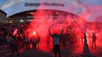 Des supporters de l'Olympique de Marseille avec des fumigènes devant le Stade Vélodrome avant un match de Ligue 1 contre Lyon le 18 mars 2018 (ANNE-CHRISTINE POUJOULAT / AFP)