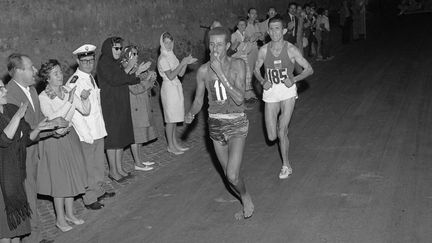 Abebe Bikila s'apprête à remporter le marathon des JO de Rome en 1960. Il domine le favori de l'épreuve, le marocain Abdeslam Radi. (- / EPU / VIA AFP)