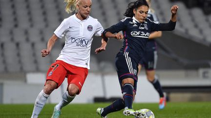 Louisa Necib (OL) à la lutte avec Caroline Seger (PSG) lors du seizième de finale de la Ligue des Champions 2014-2015 entre Paris et Lyon. (JEFF PACHOUD / AFP)