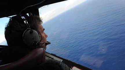 Un militaire n&eacute;o-z&eacute;landais recherche le vol MH370 au large de la c&ocirc;te ouest de l'Australie, le 13 avril 2014. (GREG WOOD / POOL)