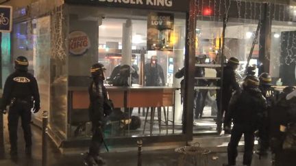 Des CRS interviennent pour déloger des manifestants du Burger King de l'avenue de Wagram, à Paris, le 1er décembre 2018. (PAUL-LUC MONNIER / STÉPHANE GUILLEMOT / FRANCE 2)