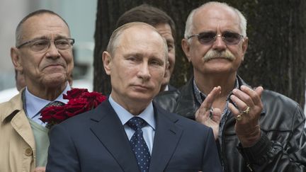 Les cin&eacute;astes&nbsp;Andrei Konchalovsky (&agrave; g.) et&nbsp;Nikita Mikhalkov (&agrave; dr.) posent derri&egrave;re le pr&eacute;sident russe Vladimir Poutine, le 28 mai 2014, &agrave; Moscou (Russie). (SERGEY GUNEEV / RIA NOVOSTI / AFP)