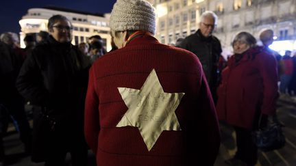 Une femme porte une étoile jaune cousue dans le dos de son pull, mardi 19 février 2019 à Nancy (Meurthe-et-Moselle). On peut y lire "Française, juive, et fière". (MAXPPP)