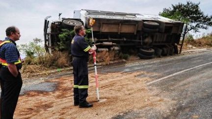 Des policiers sud-africains inspectent les lieux d'un accident de car ayant fait deux morts et 18 blessés, le 10 janvier 2010 près de Nelspruit.    (AFP PHOTO / Martin BERNETTI)