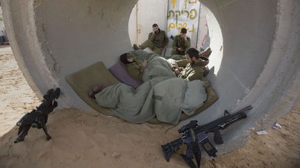 Des soldats isra&eacute;liens se mettent &agrave; l'abri des tirs de roquette palestiniens dans la bande de Gaza,&nbsp;vendredi 16 novembre 2012. (MENAHEM KAHANA / AFP)