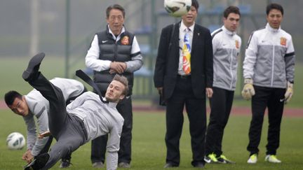 Le footballeur britannique, David Beckham, glisse sur le terrain lors d'une d&eacute;monstration &agrave; Wuhan (Chine), le 23 mars 2013. (DARLEY SHEN / REUTERS)