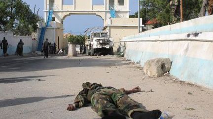 Cadavre d'un rebelle shebab près de la porte principale du palais présidentiel à Mogadiscio, le 9 juillet 2014. La veille, les islamistes y ont effectué une attaque armée.  (ABDULFITAH HASHI NOR / AFP)