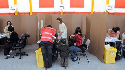 Des patients se font vacciner contre la grippe A (H1N1) dans un gymnase à Paris, le 24 novembre 2009 (LIONEL BONAVENTURE / AFP)