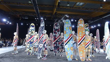 Sous les costumes, les modèles portent des maillots de bain une pièce à la forme très rétro. Leurs motifs fleuris s'harmonisent avec leur planche de surf. 
 (Corinne Jeammet)