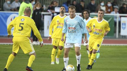 Emmanuel Macron lors du match de football amical de charité entre le Variétés Club de France (VCF) et le CHI PSG (hôpital de Poissy) au profit de la Fondation des Hôpitaux de France, le 14 octobre 2021, au Stade Léo-Lagrange de Poissy.&nbsp; (JEAN CATUFFE / AFP)