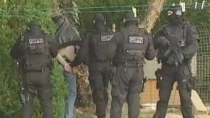 Des policiers du GIPN encadrent un homme interpell&eacute;, pr&egrave;s de Nantes (Loire-Atlantique), le 30 mars 2012. (FTVI / FRANCE 2)