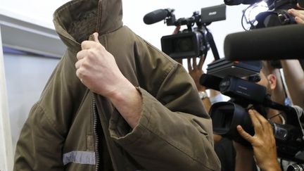 Le Français Romain Franck,&nbsp;le visage camouflé sous sa veste de prisonnier, au tribunal de&nbsp;Beer-Sheva (Israël), le 19 mars 2018. (JACK GUEZ / AFP)