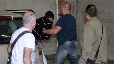 Berkane Maklouf, le compagnon de la m&egrave;re de Fiona,&nbsp;principal suspect dans le d&eacute;c&egrave;s de la petite Fiona, escort&eacute; par des policiers,&nbsp;le 26 septembre 2013 &agrave; Clermont-Ferrand (Puy-de-D&ocirc;me). (PHILIPPE DESMAZES / AFP)