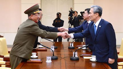 Photographie fournie apr&egrave;s le gouvernement sud-cor&eacute;en de la poign&eacute;e de main symbolisant l'accord entre la Cor&eacute;e du Nord (&agrave; g.) et la Cor&eacute;e du Sud, le 22 ao&ucirc;t 2015, dans le village frontalier de Panmunjom. (UNIFICATION MINISTRY / AFP)