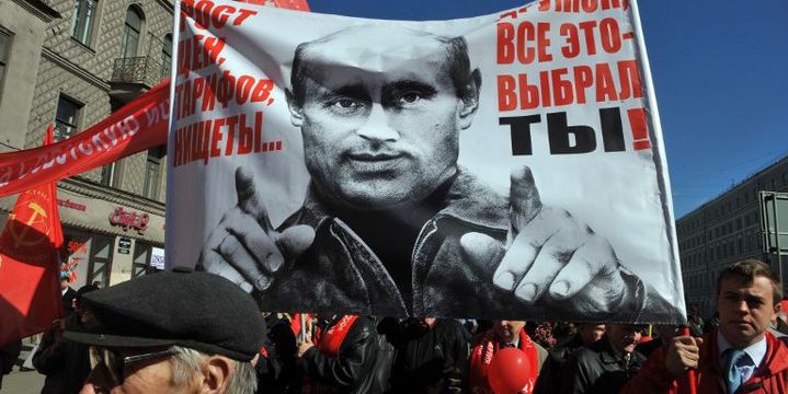 Un portrait de Vladimir Poutine accompagné des mots «Hausse des prix et de la misère, voilà pour quoi vous avez voté !» porté par des militants du Parti communiste russe pour le 1er Mai 2012 à Saint-Pétersbourg. (Olga Maltseva / AFP)