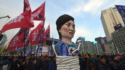 lors d'un rassemblement anti-gouvernemental demandant sa démission. La présidente sud-coréenne est impliquée dans un scandale de trafic d'influence auquel est mêlé une de ses amies proches, Choi Soon-sil, et dont les ramifications s'étendent jusqu'aux grands conglomérats sud-coréens, les «chaebols». Si la présidente devait être destituée, comme le demandent les partis d'oppostion, une nouvelle élection présidentielle aurait lieu dans les 60 jours pour désigner celui ou celle qui irait au terme du mandat en cours. Les trois partis d'opposition, qui contrôlent au total 165 des 300 sièges de députés, auront besoin des voix de parlementaires du parti Saenuri, la formation de la présidente, pour atteindre la majorité des deux tiers nécessaire à l'adoption de la motion de destitution. (UNG Yeon-Je / AFP ( 30 /11/2016))