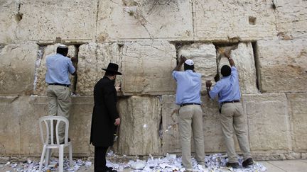 Le rabbin Shmuel Rabinovitz (2e G) et des employ&eacute;s enl&egrave;vent les petits mots gliss&eacute;s dans le Mur des Lamentations &agrave; J&eacute;rusalem (Isra&euml;l), le 28 mars 2012. (AMMAR AWAD / REUTERS)