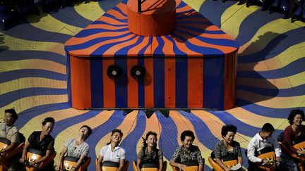 Des Nord-Cor&eacute;ens profitent d'un man&egrave;ge dans un parc d'attractions &agrave; Pyongyang (Cor&eacute;e du Nord), le 3 septembre 2014. (WONG MAYE-E / AP / SIPA)