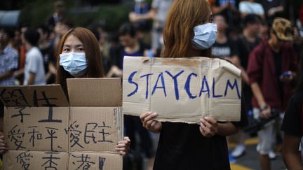 Une manifestante pro-d&eacute;mocratie tient un panneau "Restez calmes", le 1er octobre 2014, &agrave; Hong Kong. (CARLOS BARRIA / REUTERS)