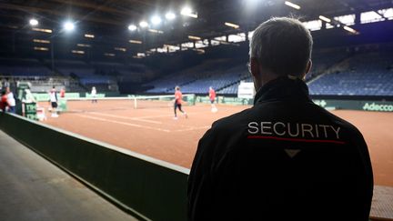 Un garde de sécurité surveille l'entraînement de l'équipe britannique de Coupe Davis, le 24 novembre 2015 à Gand (Belgique). (DIRK WAEM / BELGA / AFP)