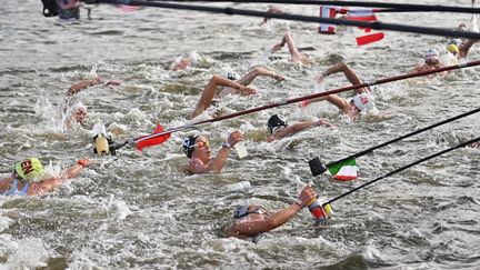 "Chouchous ! Glaces ! Beignets !" Ah non, pardon, ce n'est pas la nouvelle technique des vendeurs ambulants sur les plages, mais le ravitaillement des concurrentes du 10 km en eau libre des Jeux de Tokyo. (OLI SCARFF / AFP)