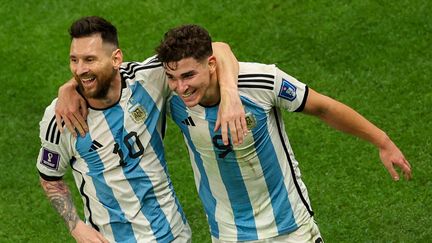 Lionel Messi et Julian Alvarez célèbrent la qualification de l'Argentine pour la demi-finale de la Coupe du monde de football au Qatar, mardi 13 décembre 2022. (ADRIAN DENNIS / AFP)