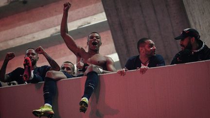 Kylian Mbappé et le reste des joueurs du Paris Saint-Germain fêtent avec les supporters parisiens leur qualification pour les quarts de finale de la Ligue des champions après la victoire contre Dortmund, en pleine pandémie de Covid-19, le 11 mars 2020. ( ANNE-CHRISTINE POUJOULAT / AFP)