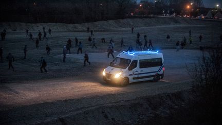 Des migrants jettent des pierres sur un camion de police, à Calais (Pas-de-Calais), le 29 février 2016.&nbsp; (JULIEN PITINOME / AFP)