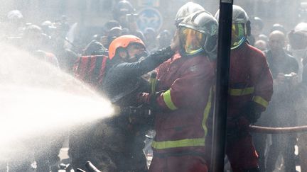 Un sapeur-pompier agressé par une manifestante, en marge du défilé du 1er-Mai à Paris. (MYLENE DEROCHE / MAXPPP)