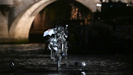 Floriane Issert, officier de Gendarmerie nationale, sur un cheval de métal, parcourt la Seine lors de la cérémonie d'ouverture des Jeux olympiques Paris 2024, le 26 juillet 2024. (KIRILL KUDRYAVTSEV / AFP)