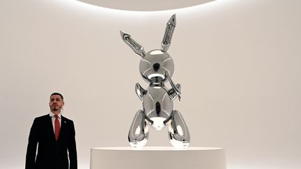 Un agent de sécurité se tient devant le "Rabbit" (Lapin) de l'artiste américain, Jeff Koons, le 3 mai 2019, à New York.&nbsp; (TIMOTHY A. CLARY / AFP)