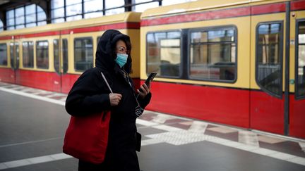 Une habitante avec un masque de protection, le 23 mars 2020, à Berlin. (ODD ANDERSEN / AFP)