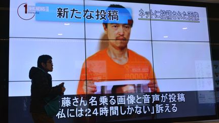 Le visage de l'otage japonais Kenji Goto sur un &eacute;cran g&eacute;ant dans les rues de Tokyo (Japon), le 28 janvier 2015.&nbsp; (KAZUHIRO NOGI / AFP)