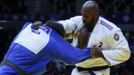 Teddy Riner face à Inal Tasoev lors de la finale des championnats du monde à Doha, le 13 mai 2023. (KARIM JAAFAR / AFP)