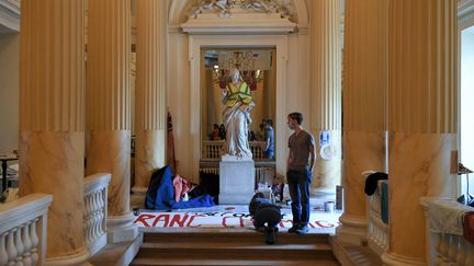 Les manifestants préparent des banderoles alors qu'ils occupent le théâtre de l'Odéon depuis le 4 mars, à Paris, le 25 mars 2021 (ALAIN JOCARD / AFP)